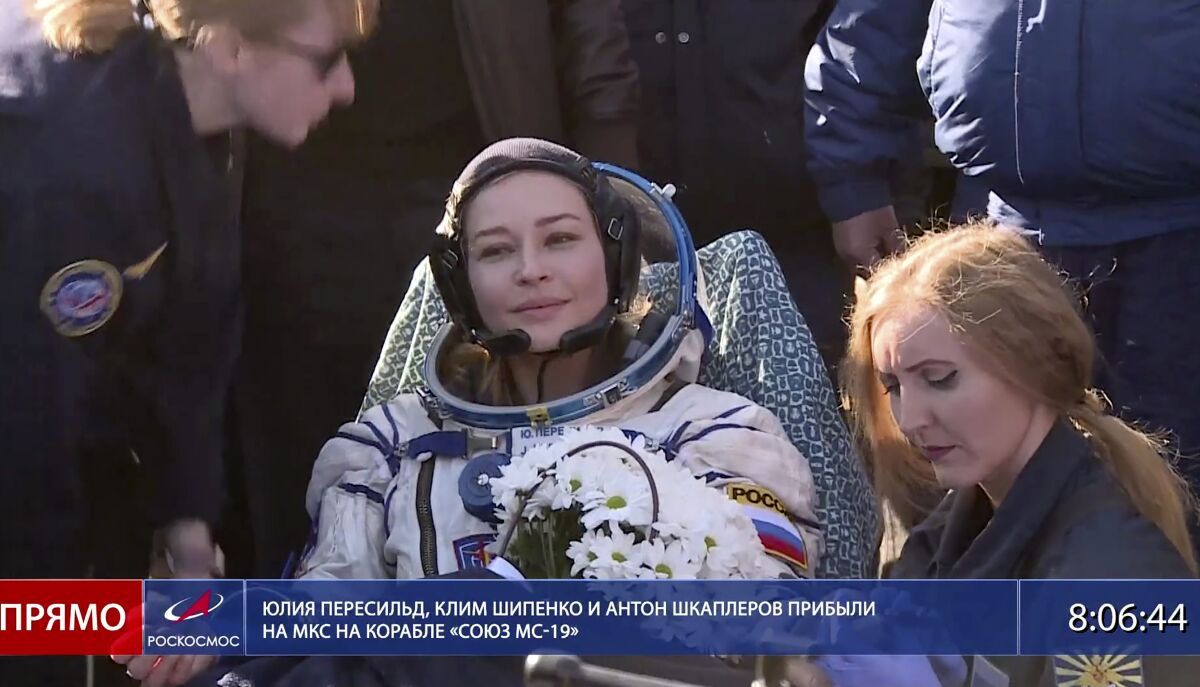 In this photo taken from video footage released by Roscosmos Space Agency, actress Yulia Peresild sits in a chair shortly after the landing of the Russian Soyuz MS-18 space capsule, southeast of the Kazakh town of Zhezkazgan, Kazakhstan, Sunday, Oct. 17, 2021. The Soyuz MS-18 capsule landed upright in the steppes of Kazakhstan on Sunday with cosmonaut Oleg Novitskiy, actress Yulia Peresild and film director Klim Shipenko aboard after a 3 1/2-hour trip from the International Space Station. (Roscosmos Space Agency via AP)
