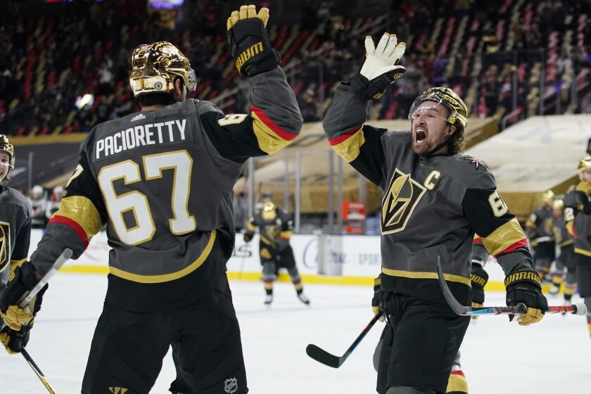 Vegas Golden Knights right wing Mark Stone, right, celebrates after left wing Max Pacioretty, left, scored against the Minnesota Wild during overtime of an NHL hockey game Monday, March 1, 2021, in Las Vegas. (AP Photo/John Locher)
