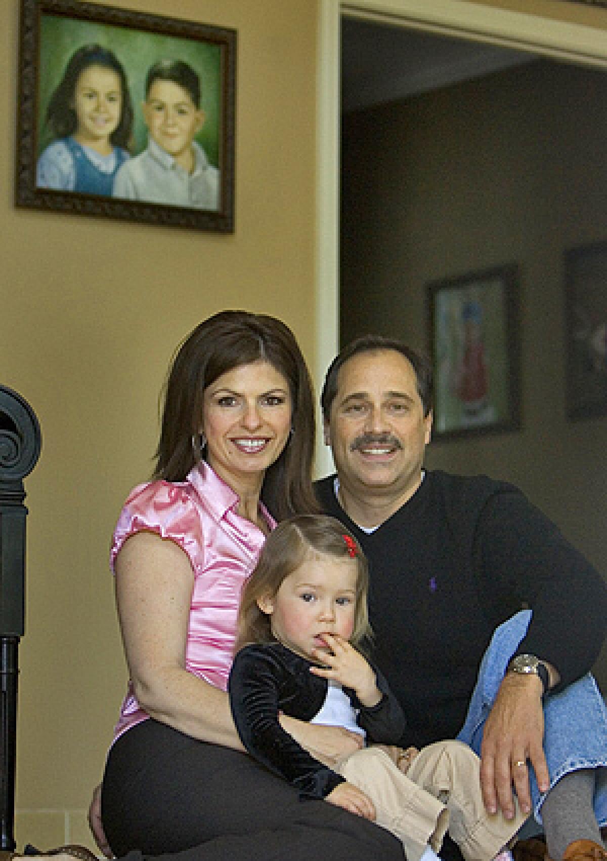 Bob and Carmen Pack play with their two-year-old daughter Noelle, in front of a painting of the couple's deceased children Troy and Alana, April 25, 2008 in Danville, California. They were killed nearly five years ago when a woman, under the influence of prescription drugs and alcohol hit them with her car while they were walking with their mother.