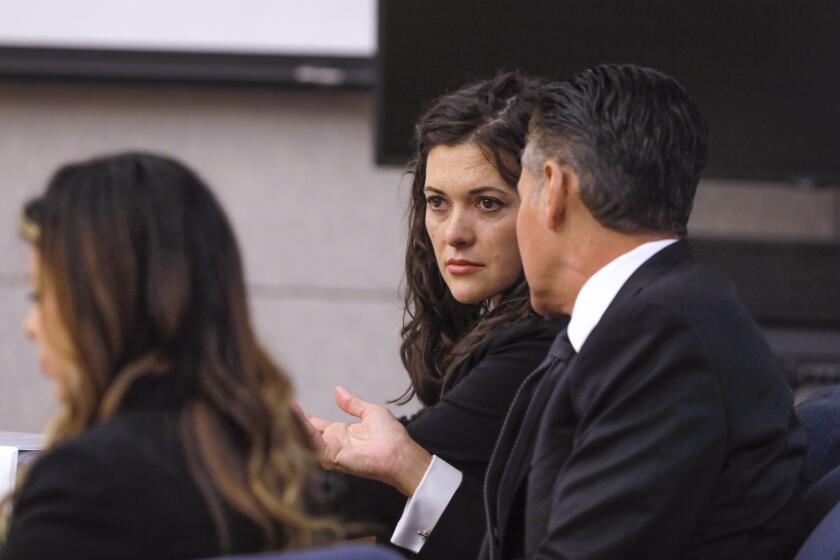 Vista, CA - December 07: Jade Janks listens to the opening statement of prosecutor Jorge Del Portillo on the first day of her murder trial at the Vista Courthouse. With her is her legal team, lawyers Marc Carlos and Michelle Camacho, at left. (Charlie Neuman / For The San Diego Union-Tribune)