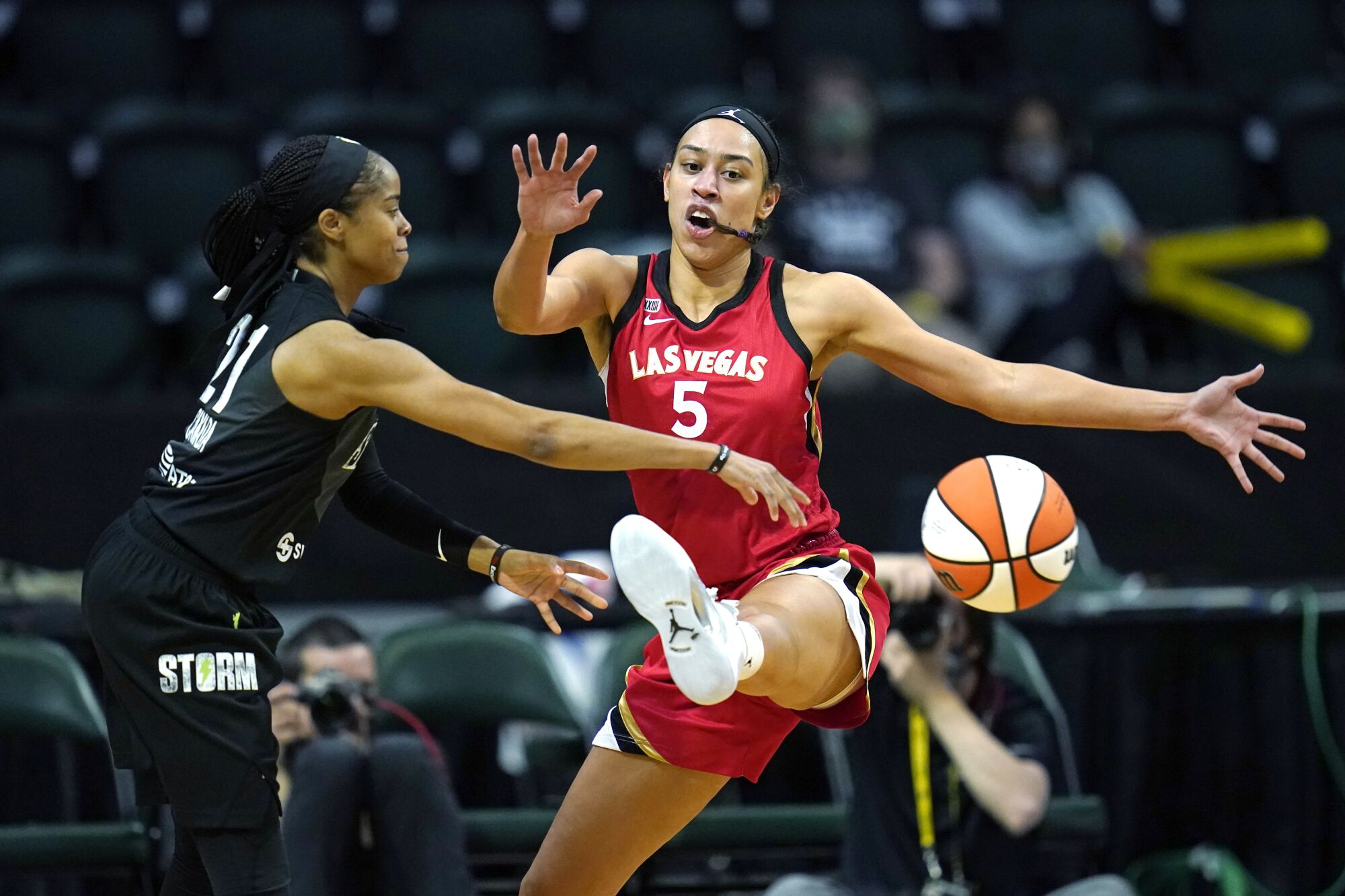 Jordin Canada makes a pass above the kicked out leg of Aces guard Dearica Hamby.