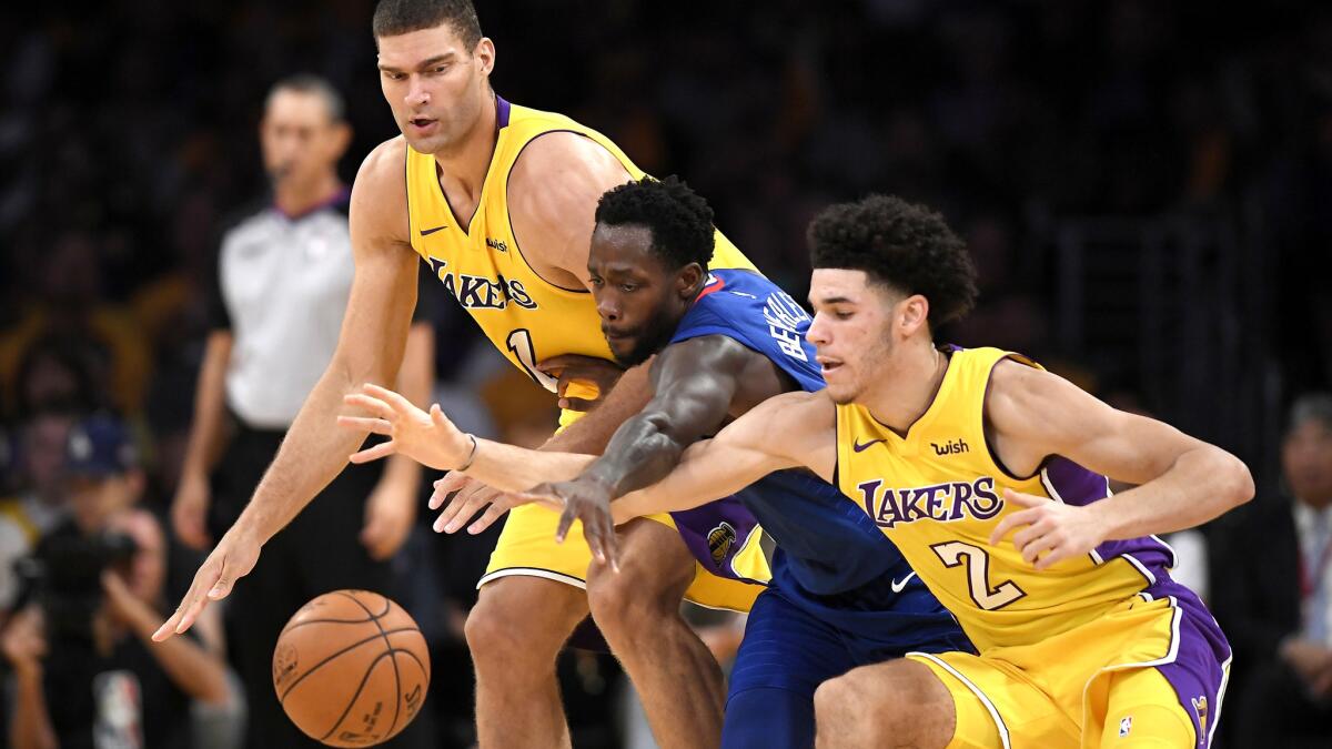 Clippers guard Patrick Beverley fights for a loose ball against Lakers center Brook Lopez, left, and guard Lonzo Ball during the first half Thursday.