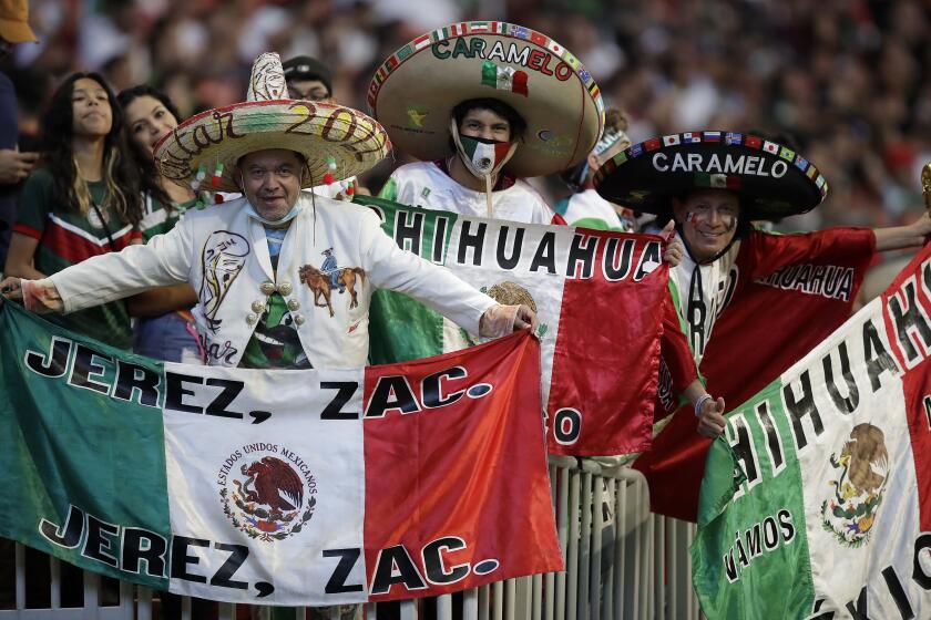 Soccer fans hold flags prior to an international friendly soccer match between Mexico and Honduras, Saturday, June 12, 2021, in Atlanta. (AP Photo/Ben Margot)