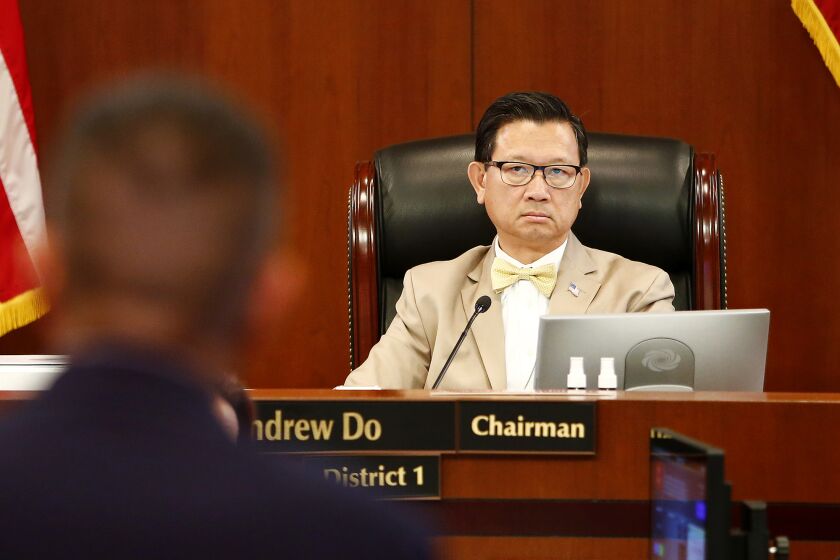 County Supervisor Andrew Do listens as Public Health officer Clayton Chau, left, speaks during an Orange County Board of Supervisors meeting in Santa Ana on Tuesday, August 10, 2021.