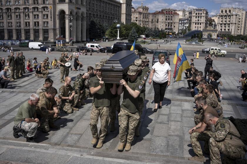 Ukrainian servicemen carry the coffin of British combat medic, volunteer, Peter Fouche, 49 who was killed on June 27 during his work in East Ukraine, at the funeral ceremony on the city's main square in Kyiv, Ukraine, Saturday, July 6, 2024. Peter was founder of a charity organization, which provides vehicles, drones and other needs to Ukrainian servicemen. (AP Photo/Alex Babenko)