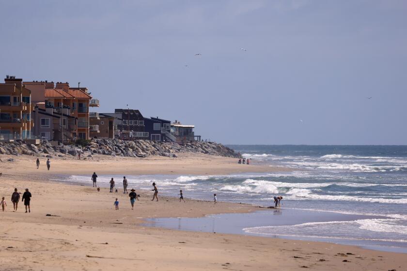 Imperial Beach, CA - April 24: People walk along the coast in Imperial Beach on Wednesday, April 24, 2024. The water in the area has been contaminated for years from the Tijuana River sewage. (K.C. Alfred / The San Diego Union-Tribune)