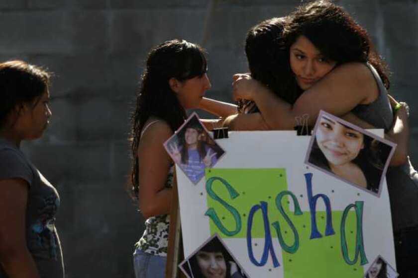 Yuritzi Meza, 16, (far right) hugs Jessica Valiente, (second from right) at a fundraiser for the family of 15-year-old Sasha Rodriguez, who died from a suspected drug overdose during the Electric Daisy Carnival, at Allessandro Elementary School in Los Angeles. Rodriguez's teammates on the 1st Impressions drill team, a hip hop dance team, helped organize the fundraiser for the family.
