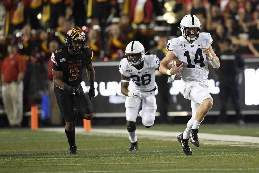 Penn State quarterback Sean Clifford (14) scrambles with the ball against Maryland defensive back Nick Cross (3) during the first half of an NCAA college football game, Friday, Sept. 27, 2019, in College Park, Md. Also seen is Penn State running back Devyn Ford (28). (AP Photo/Nick Wass)