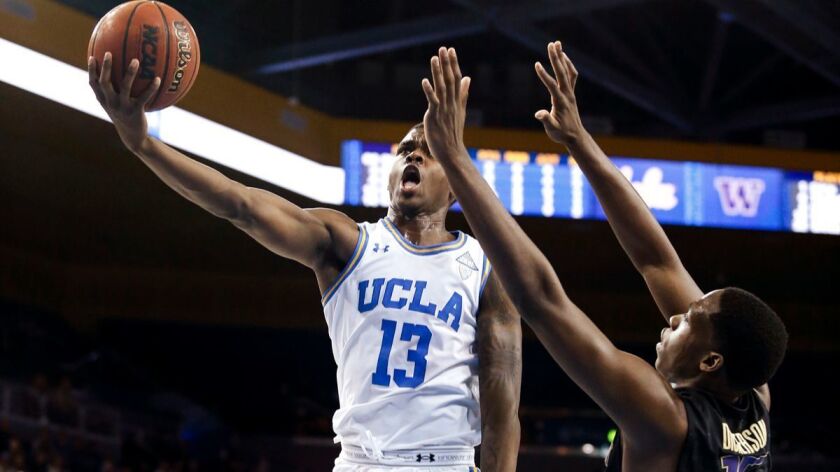 UCLA guard Kris Wilkes goes to the basket while defended by Washington forward Noah Dickerson during the second half on Sunday,