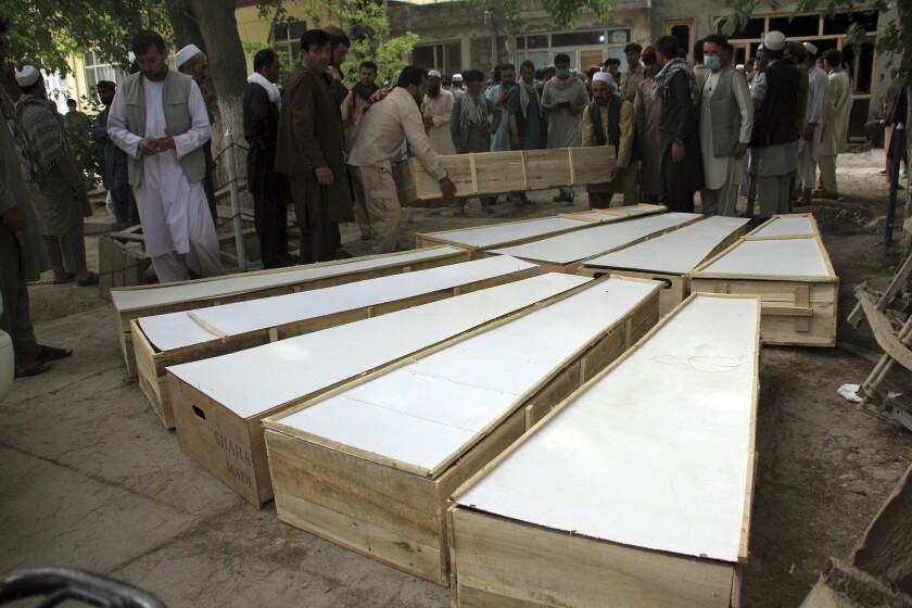 The coffins of the victims in Tuesday's attack are placed on the ground at a hospital in northern Baghlan province, Afghanistan, Wednesday, June 9, 2021. Workers of the HALO Trust de-mining organization were attacked on Tuesday night by the armed gunmen. (AP Photo/Mehrab Ibrahimi)