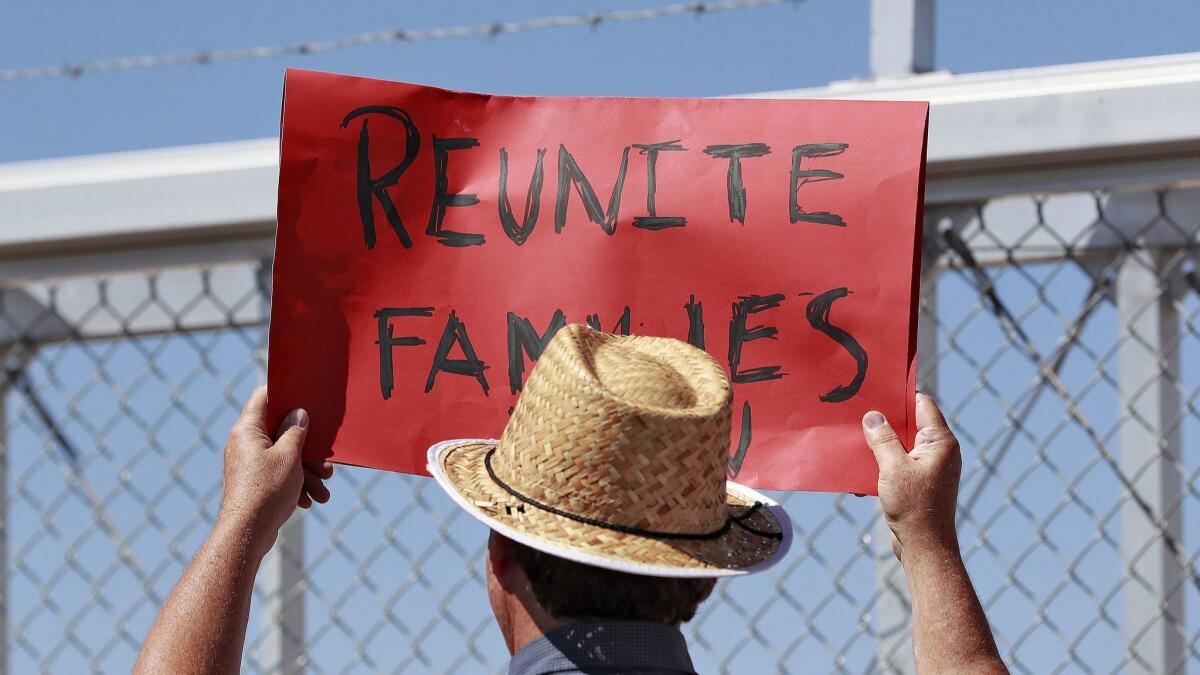 A protester holds a sign outside a closed gate at the Port of Entry facility in Fabens, Texas, on June 21.