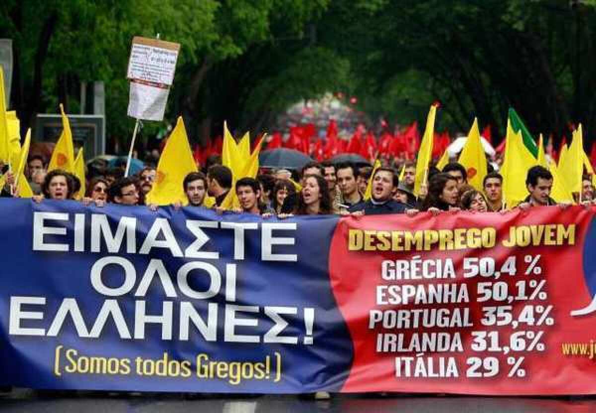 Young protesters carry a banner bearing the slogan "We are all Greek" and statistics for youth unemployment in some European Union countries during a march in Lisbon on April 25. Euro zone unemployment is now at a record high since the euro debuted in 1999.