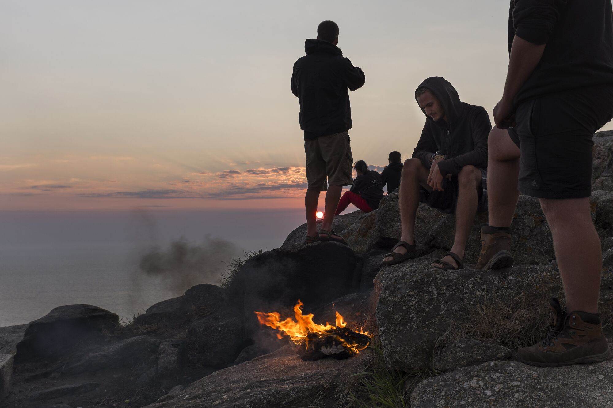 Pilgrims enjoying sunset at the Cape of Fisterra.