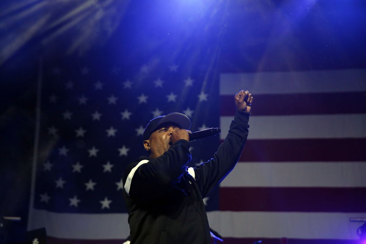 A rapper performs in front of an American flag