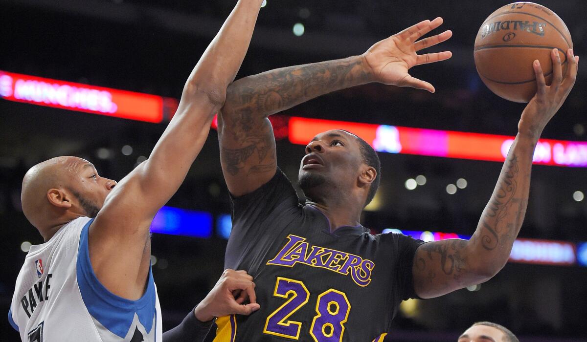 Lakers forward Tarik Black tries to score against Timberwolves forward Adreian Payne defends during the first half Friday night at Staples Center.