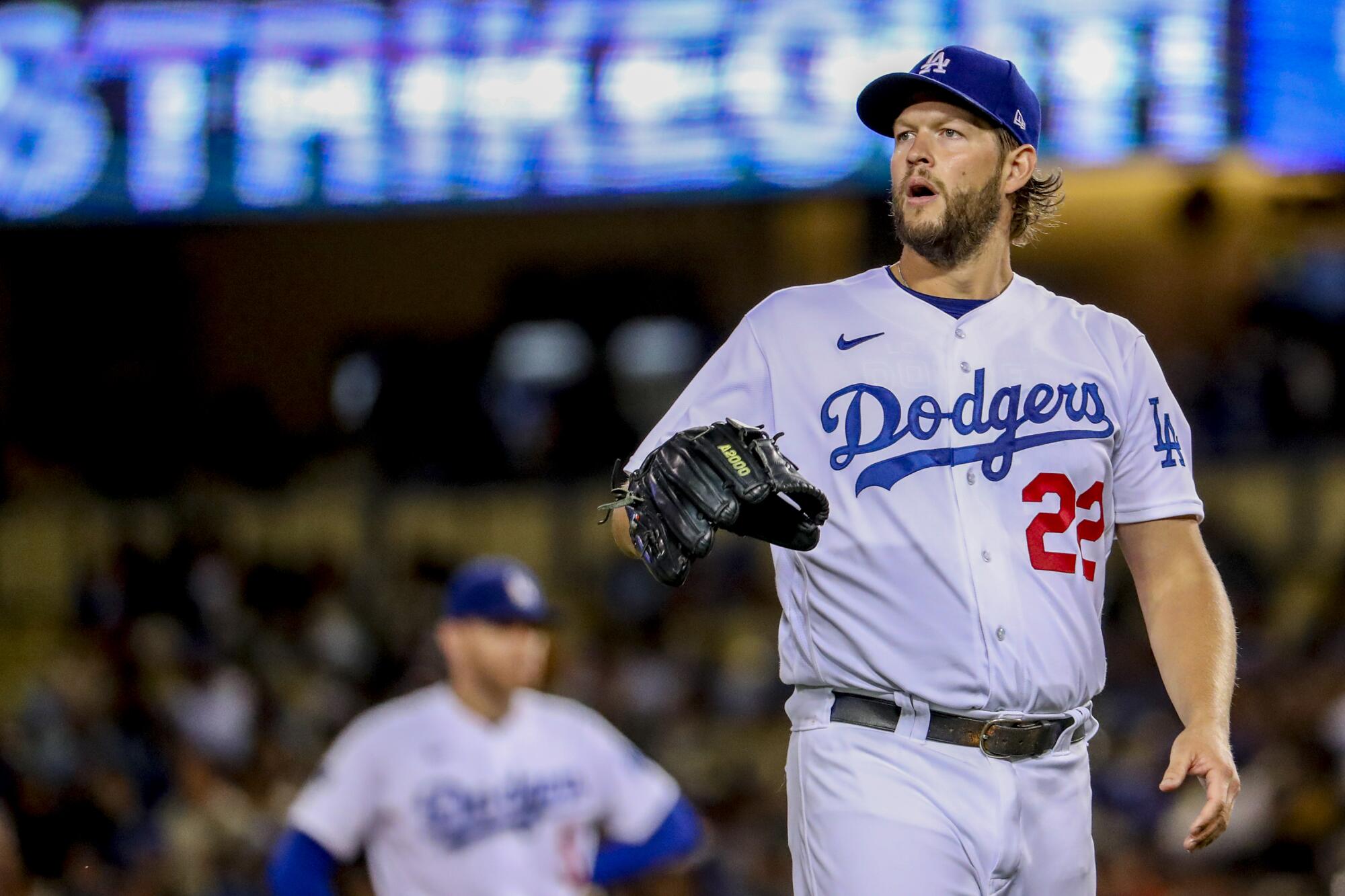 Dodgers starting pitcher Clayton Kershaw walks back to the mound after striking out a batter against the Diamondbacks