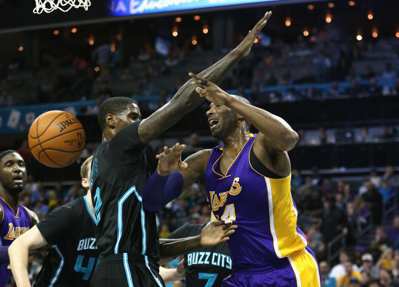 Lakers forward Kobe Bryant attempts to pass around Hornets forward Marvin Williams.