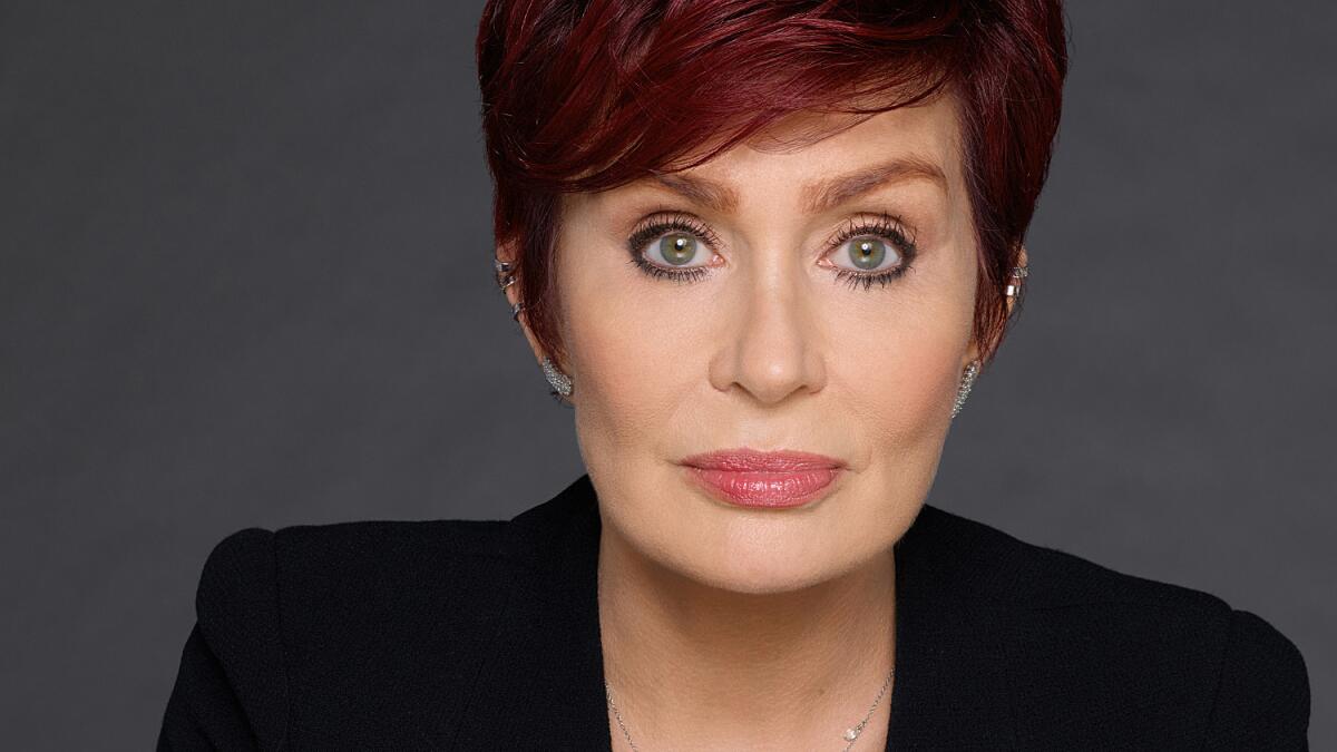 A closeup portrait of Sharon Osbourne with short red hair