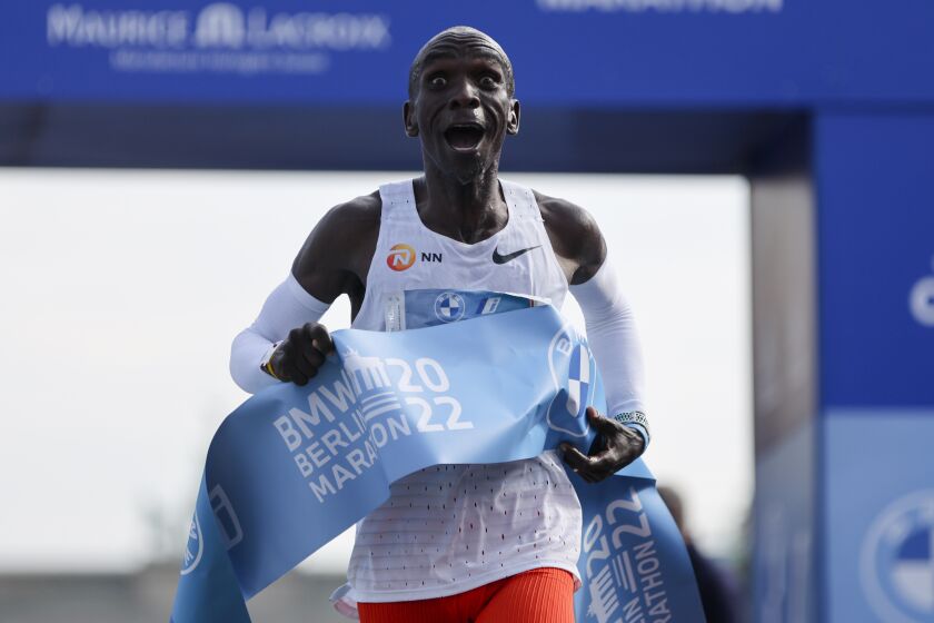 Kenya's Eliud Kipchoge crosses the line to win the Berlin Marathon in Berlin, Germany, Sunday, Sept. 25, 2022. Olympic champion Eliud Kipchoge has bettered his own world record in the Berlin Marathon. Kipchoge clocked 2:01:09 on Sunday to shave 30 seconds off his previous best-mark of 2:01:39 from the same course in 2018. (AP Photo/Christoph Soeder)