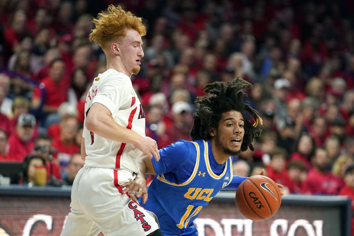 UCLA guard Tyger Campbell drives on Arizona guard Nico Mannion on Saturday in Tucson.