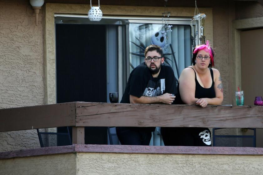 Neighbors watch as authorities search an apartment in North Phoenix believed to be the home of two gunmen who were fatally shot at the Garland, Texas, center hosting the exhibit and Muhammad cartoon contest.