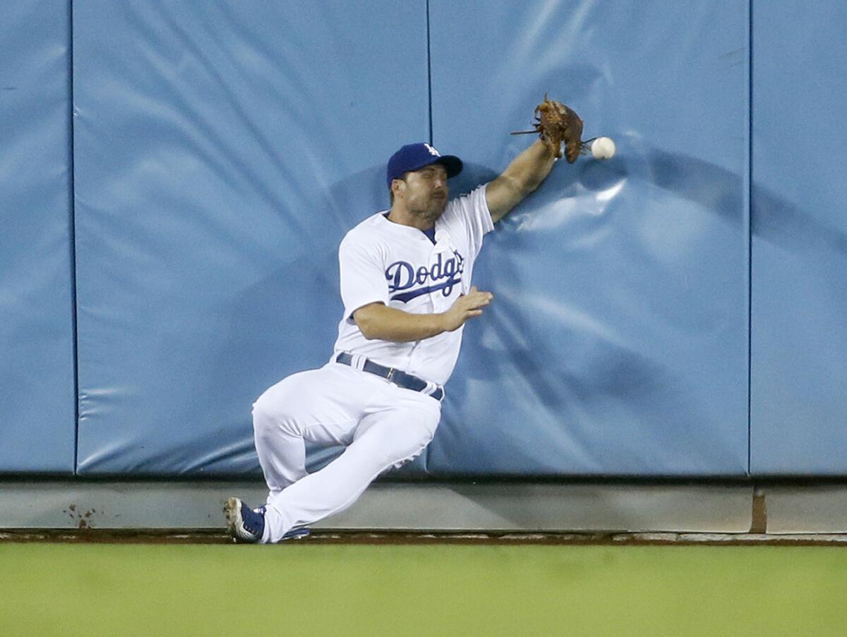 Chris Heisey is unable to catch a ball hit for a triple by Colorado first baseman Justin Morneau during the 11th inning of the Dodgers' 4-3 loss to the Rockies in 16 innings.