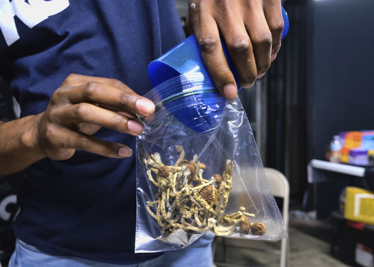 A vendor bags psilocybin mushrooms at a cannabis marketplace in Los Angeles in 2019.