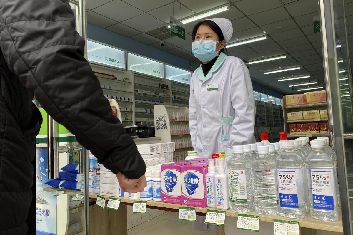 A pharmacy worker in Beijing helps a visitor on Thursday.