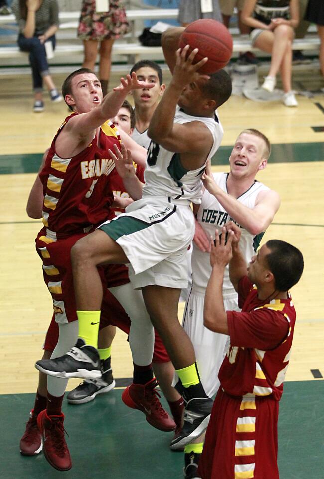 Costa Mesa's Oronde Crenshaw drives the basket after getting a rebound during Orange Coast League game action against Estancia on Wednesday at Costa Mesa.