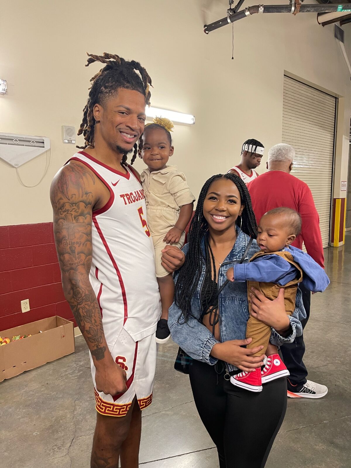 Isaiah White holds his daughter, Amari, while posing for a family photo with his wife, Jazmine, and son, Xavier.