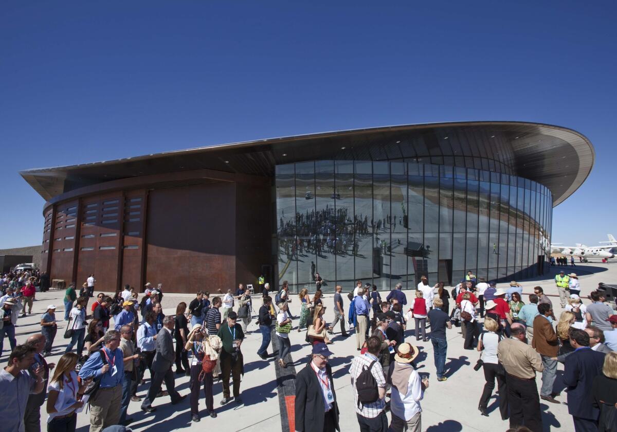 Guests stand outside the new Spaceport America hangar Monday, Oct. 17, 2011 in Upham, N.M. British billionaire Richard Branson dedicated the newly completed terminal Monday where his Virgin Galactic is slated to begin his commercial space tourism venture from the remote patch of desert in Sierra County. (AP Photo/Matt York)