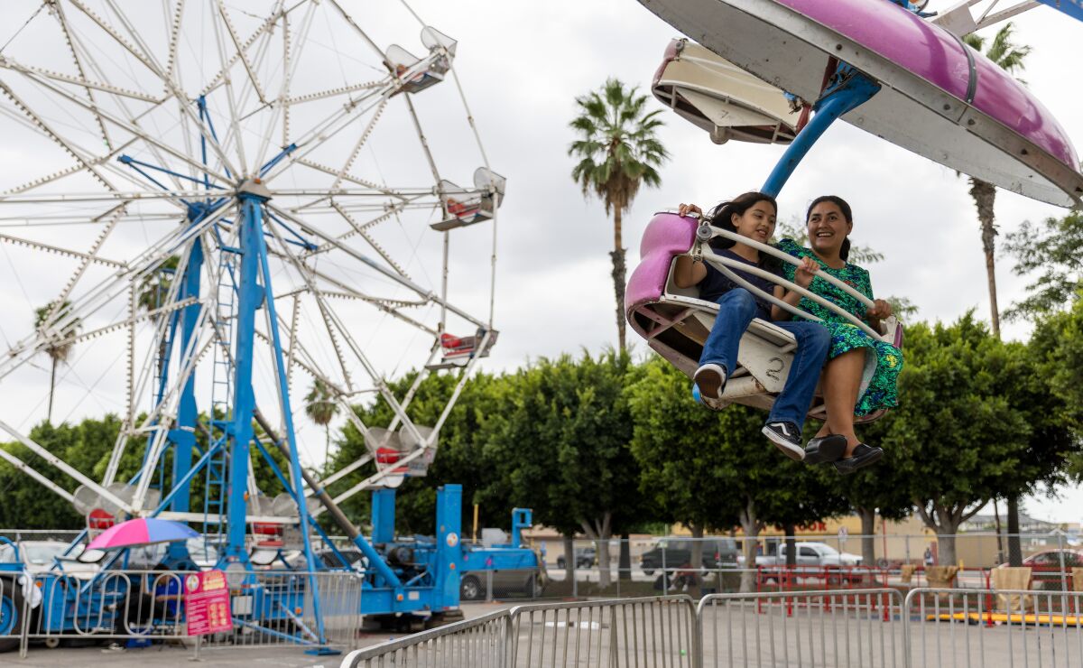 Los asistentes al carnaval Fiestas Patrias disfrutan de paseos y juegos en el mercado interior de Anaheim el sábado.