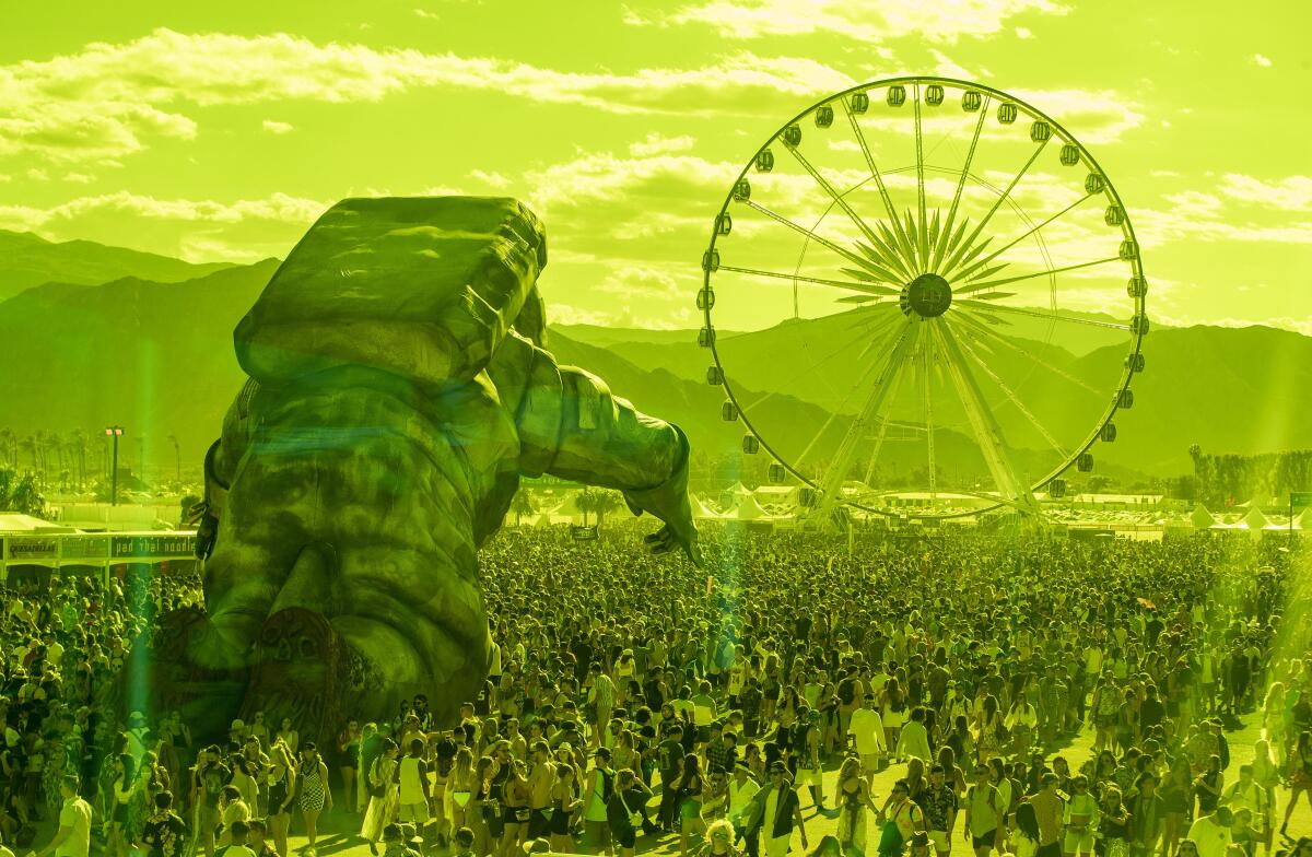 As seen through green plexiglass, a massive astronaut figure and a Ferris wheel tower over the crowd on day one of the Coachella Valley Music and Arts Festival.