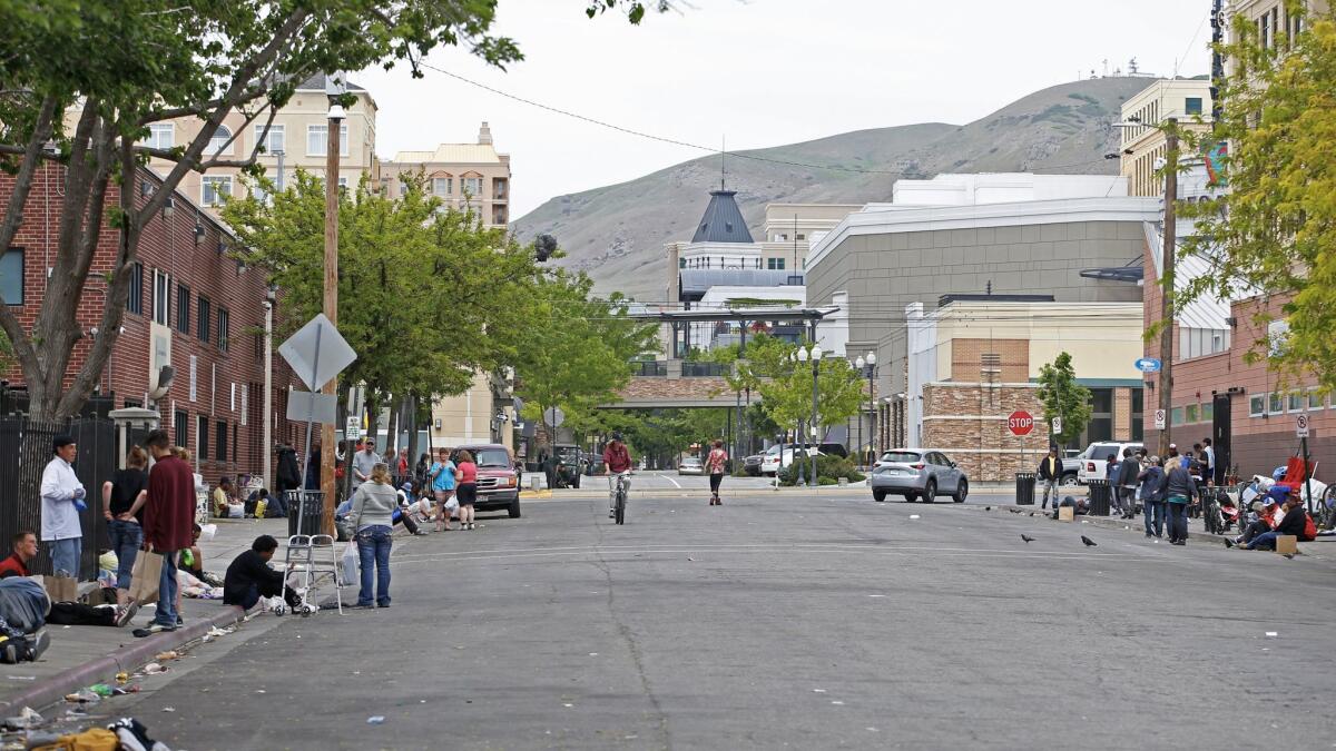 People linger outside Salt Lake City's Road Home shelter on Rio Grande Street in view of the Gateway, a high-end retail shopping center.