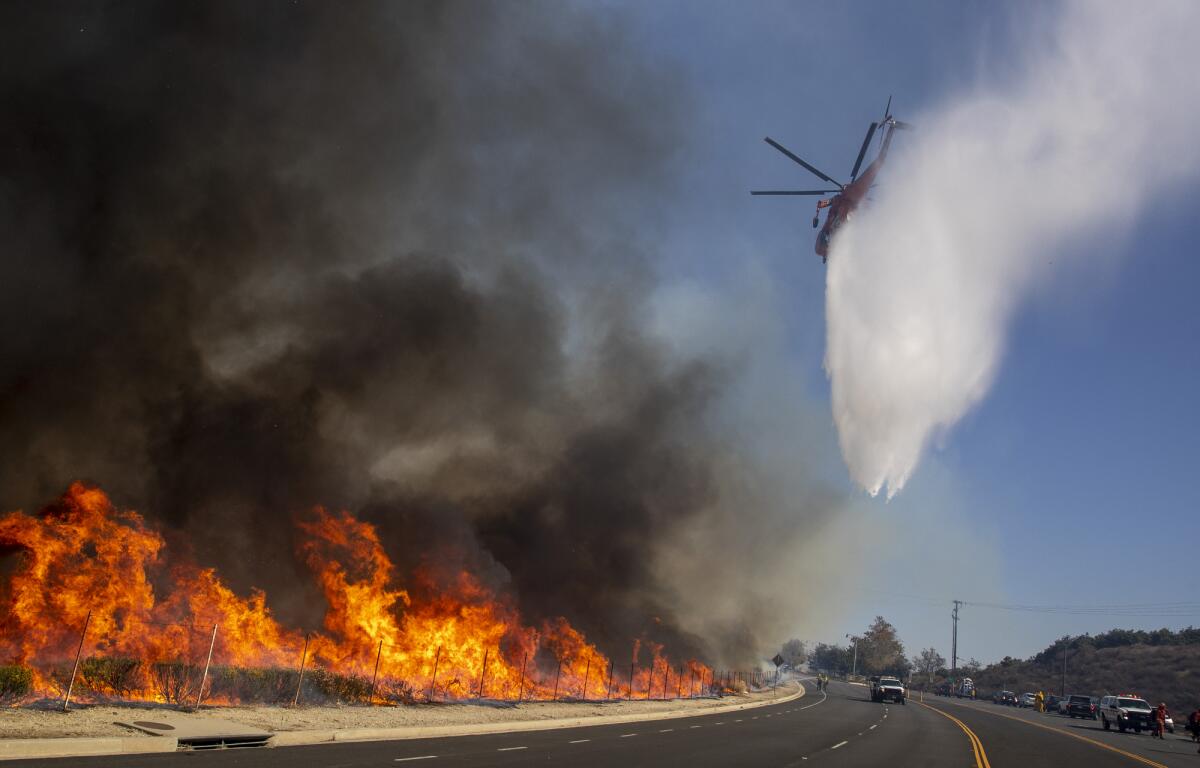 Firefighting helicopter drops water on fire in Simi Valley