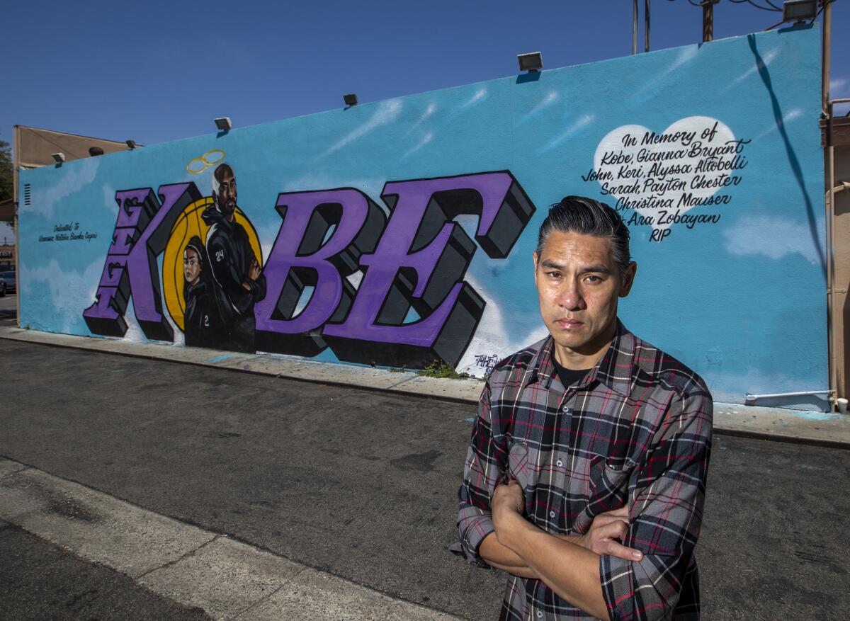 Artist Tyke Witnes stands in front of his Kobe mural at El Toro Bravo Tortilleria in Costa Mesa.