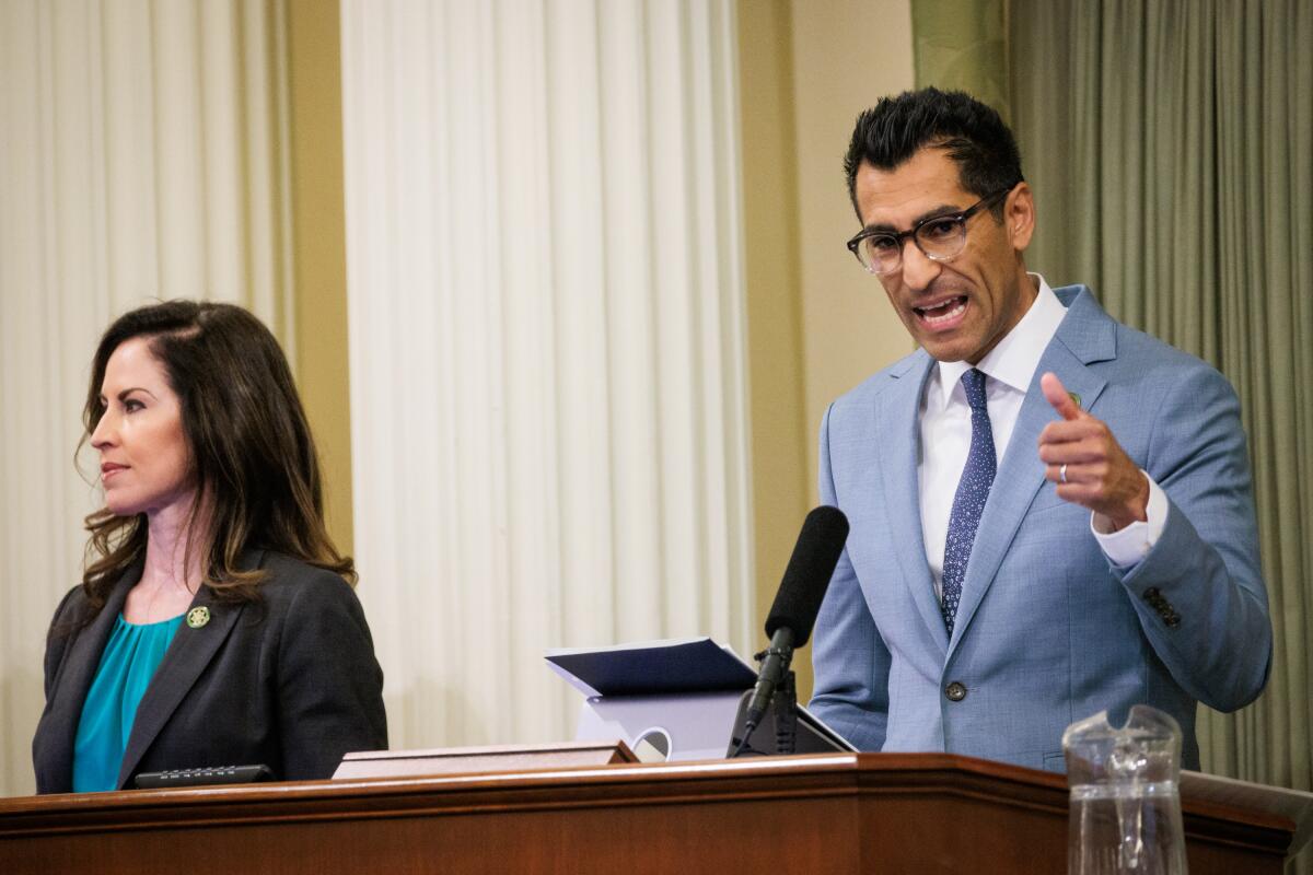 California Assembly Speaker Robert Rivas gives his inaugural speech while a woman stands nearby.