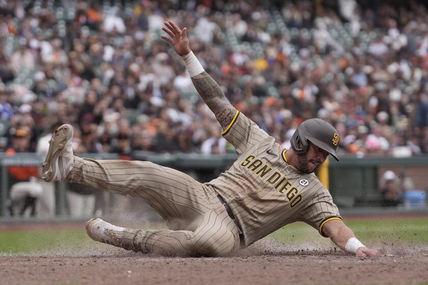 El venezolano de los Padres de San Diego, David Peralta se desliza hacia el plato para anotar ante los Gigantes de San Francisco durante la décima entrada del juego de béisbol en San Francisco, el domingo 15 de septiembre de 2024. (AP Foto/Jeff Chiu)