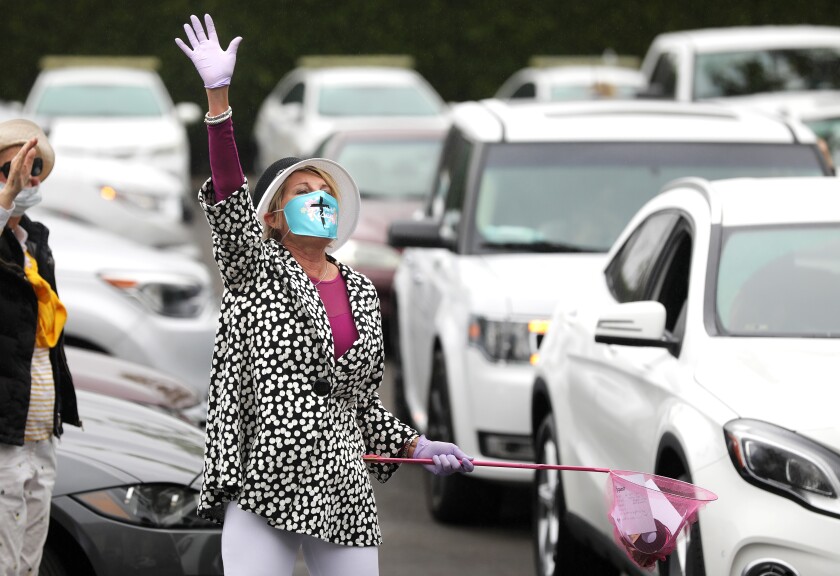 MaryAnn Lawson collects prayer requests from people gathering in their cars in a Santa Ana parking lot to worship at an Easter service by the Rev. Robert A. Schuller on Sunday.