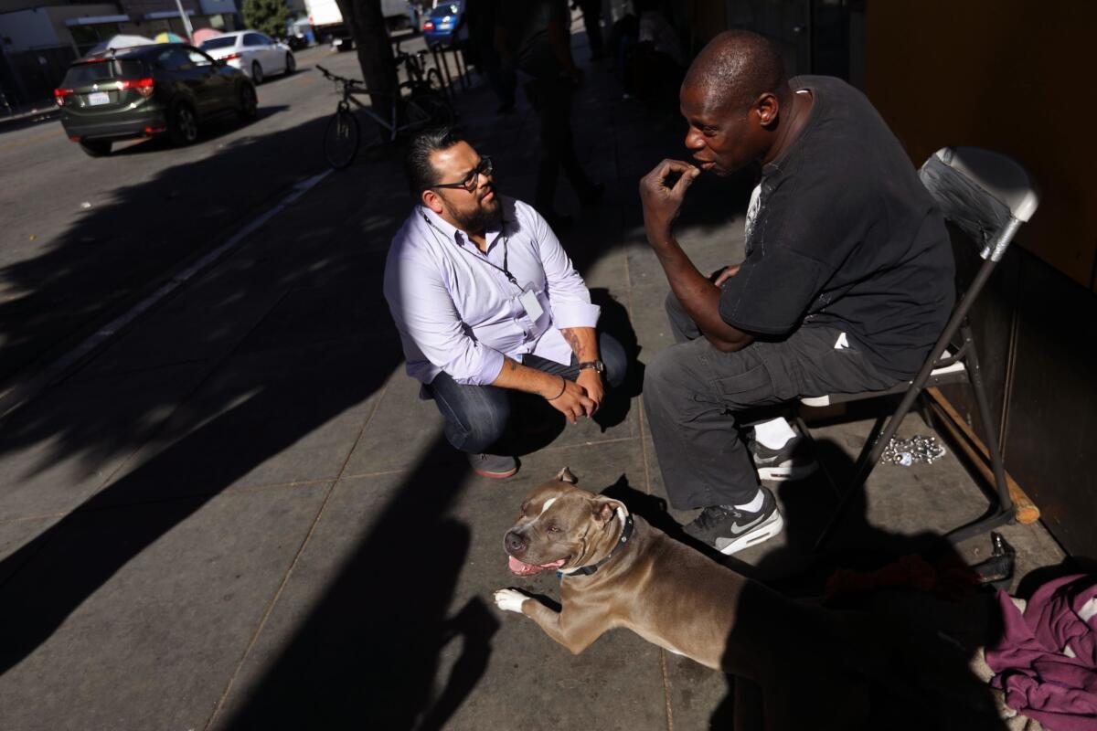 New MacArthur Fellow and L.A. Phil violinist Vijay Gupta, left, visits with Kelvin Jefferson, 55, who lives in skid row with his dog Prince on Oct. 18.