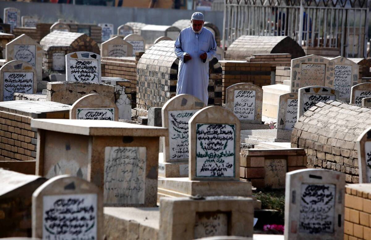 An Iraqi visits a relative's grave in Baghdad for the Eid al-Adha holiday. A new study estimates that nearly half a million Iraqis died as a result of the Iraq war.