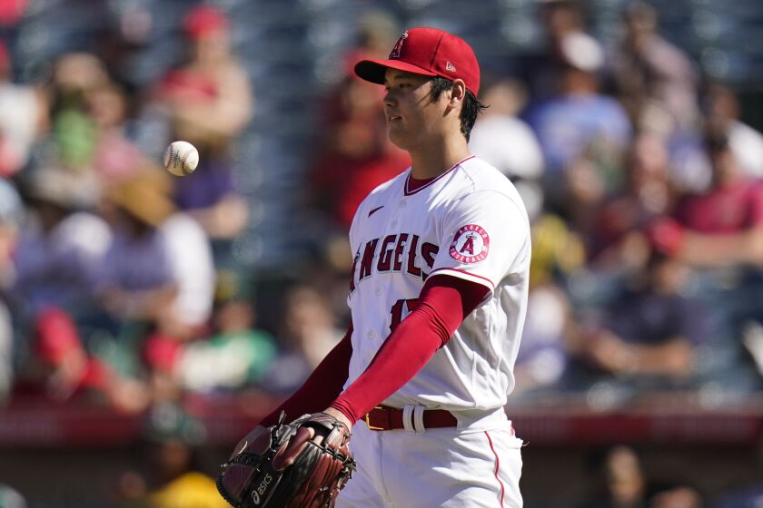 Los Angeles Angels starting pitcher Shohei Ohtani tosses the ball while pitching against the Oakland Athletics.