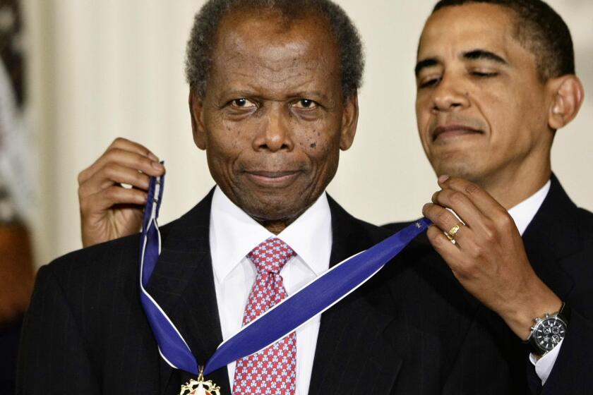 FILE - President Barack Obama presents the 2009 Presidential Medal of Freedom to Sidney Poitier during ceremonies in the East Room at the White House in Washington on, Aug. 12, 2009. Poitier, the groundbreaking actor and enduring inspiration who transformed how Black people were portrayed on screen, became the first Black actor to win an Academy Award for best lead performance and the first to be a top box-office draw, died Thursday, Jan. 6, 2022 in the Bahamas. He was 94. (AP Photo/J. Scott Applewhite, File)