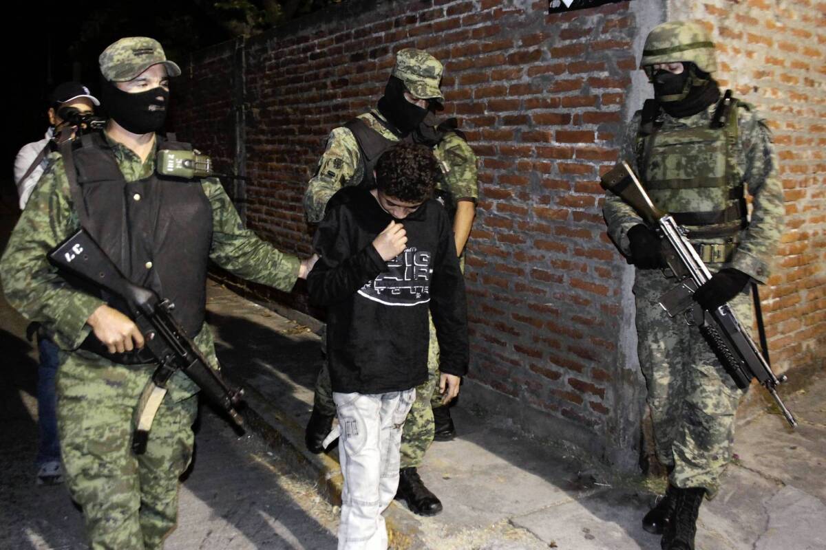 Mexican soldiers escort Edgar Jimenez Lugo, known as "El Ponchis," in Cuernavaca, Mexico, at the time of his arrest in December 2010, when he was 14. Having served three years behind bars -- then the maximum for a minor in Morelos state -- Jimenez was released Tuesday and will soon be settling in the United States, where he was born.