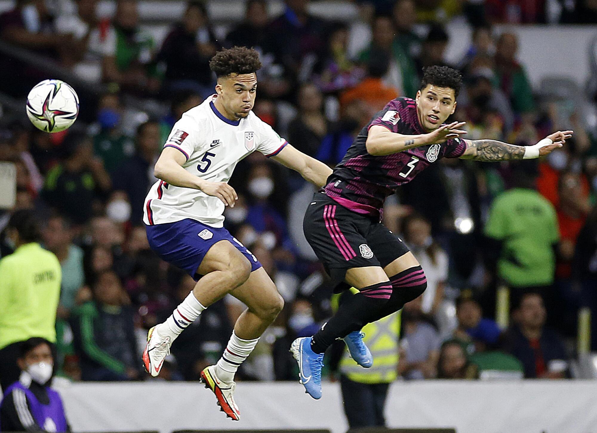 U.S. defender Antonee Robinson, left, and Mexico defender Jorge Sánchez jump for the ball during the first half.
