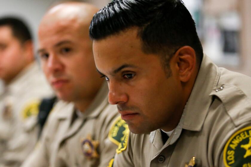 In the aftermath of the ambush slayings of five police officers in Dallas, Los Angeles County Sheriff's Deputies M. Guevara and A. Federico listen during their afternoon briefing at the Compton Sheriff Station.