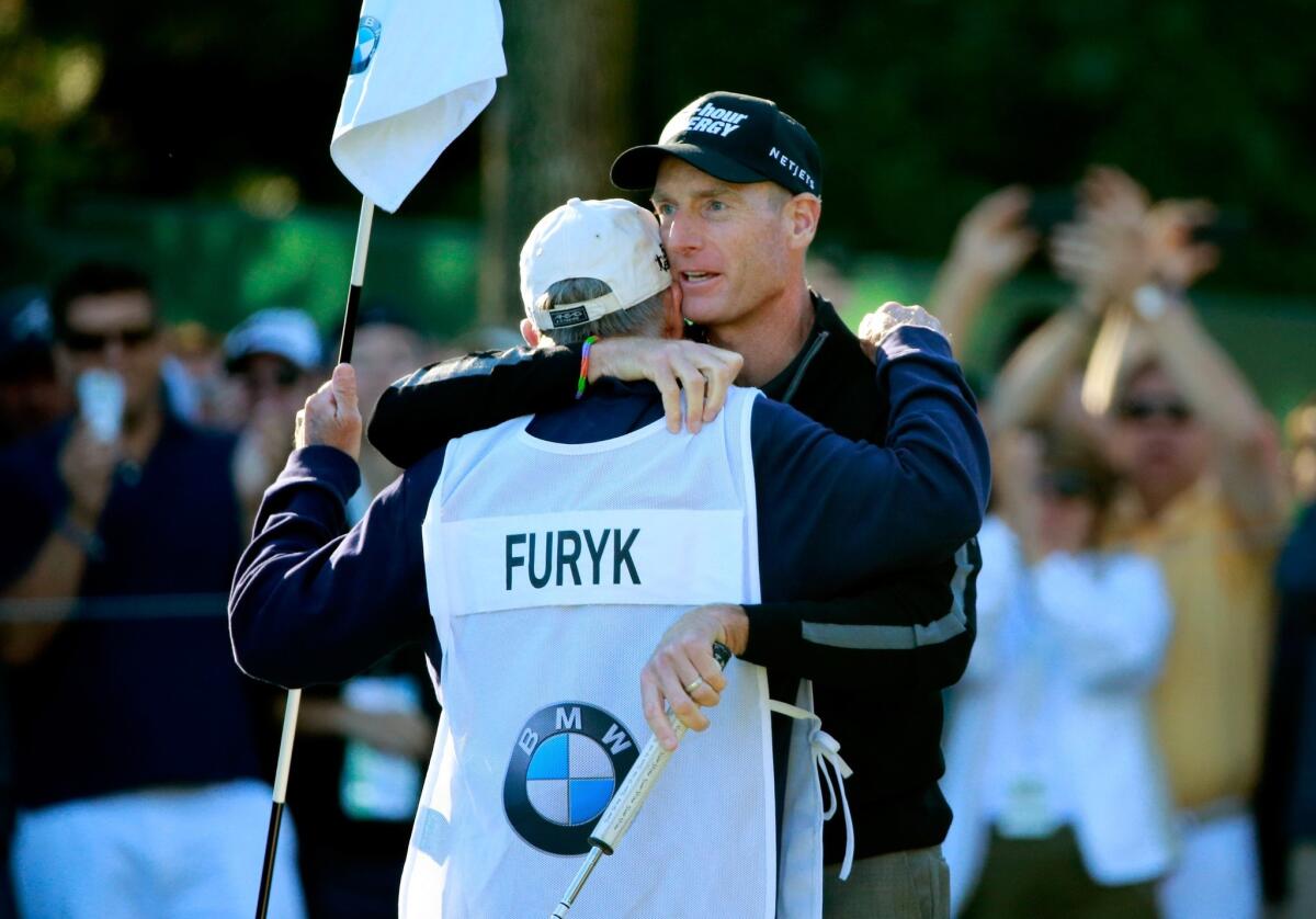 Jim Furyk hugs his caddie Mike Cowan after shooting a round of 59 at the BMW Championship on Friday.