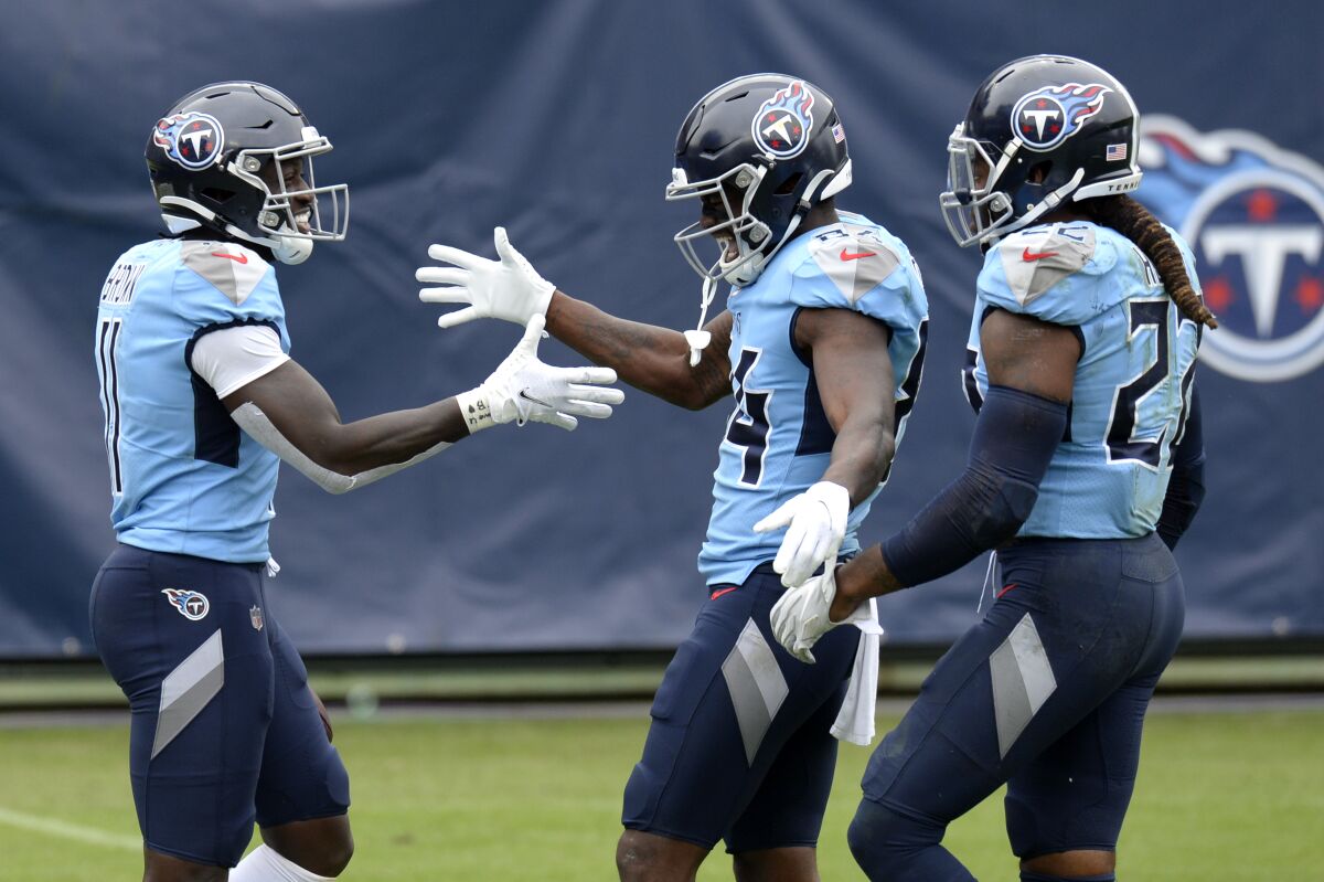 FILE - In this Oct. 25, 2020, file photo, Tennessee Titans wide receiver A.J. Brown (11) is congratulated by Corey Davis (84) and Derrick Henry (22) after Brown scored a touchdown on a 73-yard pass reception in the second half of an NFL football game against the Pittsburgh Steelers in Nashville, Tenn. Tennessee has been looking for years for top wide receivers, and the Titans now have two in A.J. Brown and Corey Davis who make big plays with key catches while also blocking for Henry whenever the NFL's leading rusher has the ball. (AP Photo/Mark Zaleski, File)