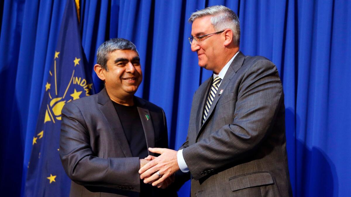 Infosys Chief Vishal Sikka and Indiana Gov. Eric J. Holcomb greet each other in Indianapolis.