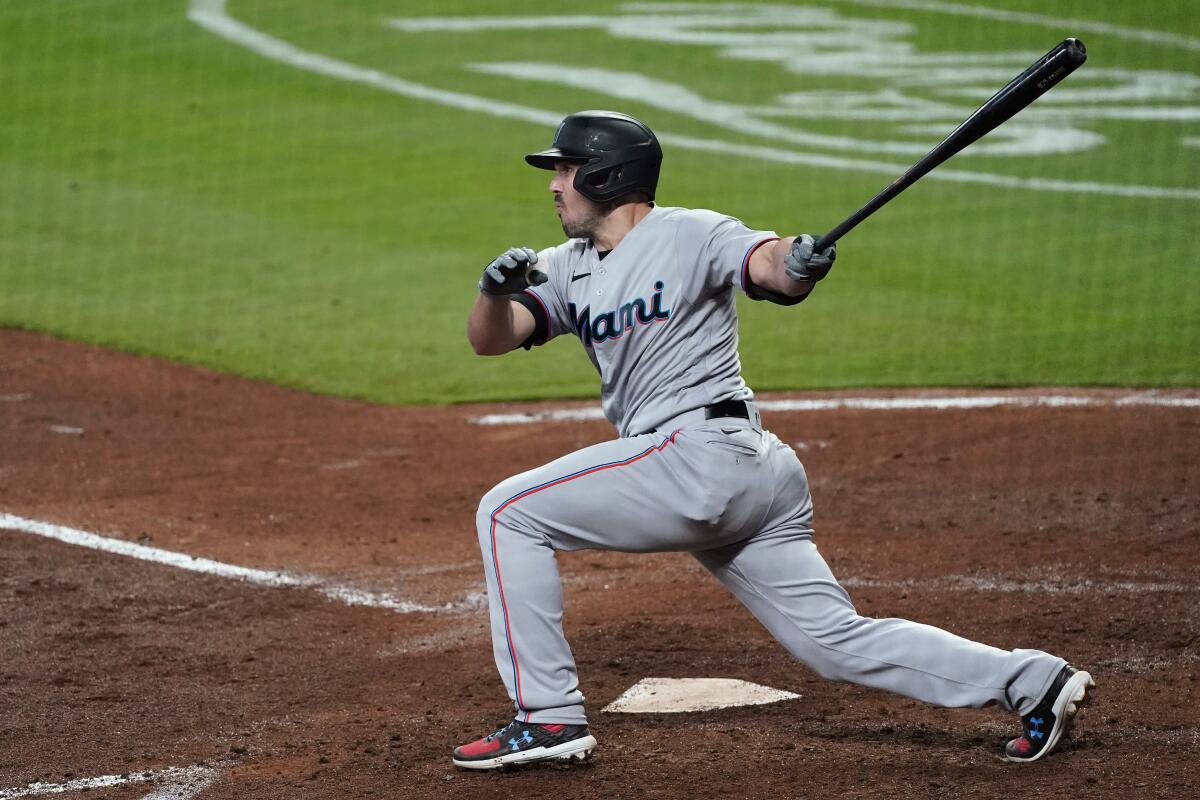 Miami Marlins' Adam Duvall follows through on a two-run double during the fourth inning of the team's baseball game against the Atlanta Braves on Tuesday, April 13, 2021, in Atlanta. (AP Photo/John Bazemore)